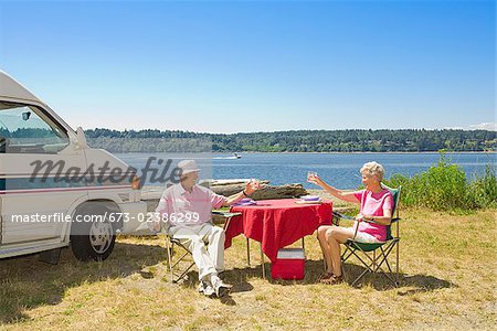 Couple holding glasses of wine at a beach, Washington State, USA