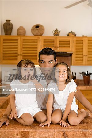 Portrait d'un homme avec ses filles dans la cuisine