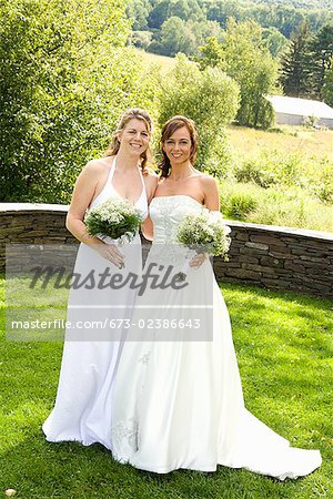 Bride standing with her bridesmaid in a park, East Meredith, New York State, USA