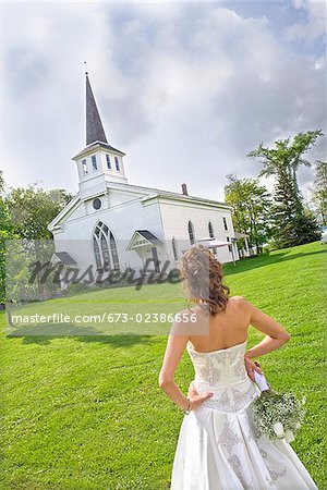 Bride standing near a church, East Meredith, New York State, USA