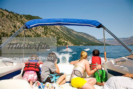 Familie in einem Motorboot und Blick auf eine Person Wasserski, Lake Chelan, Washington State, USA