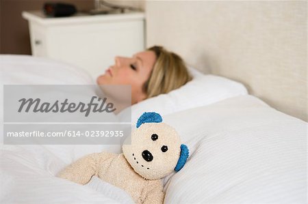 Femme au lit avec teddy bear