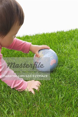 Toddler baby playing with globe