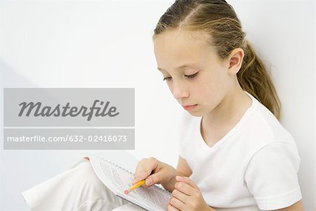Mädchen an die Wand gelehnt lesen Notebook, mit Bleistift