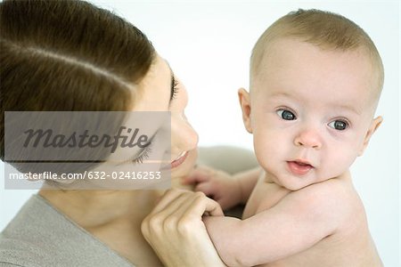 Mother holding infant, baby looking away