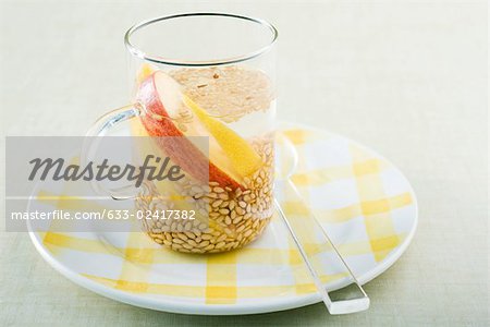 Graines de sésame, flottant dans le gobelet avec des tranches de citron et de pomme