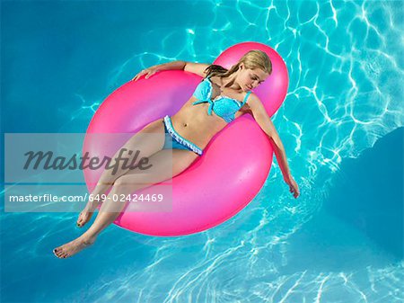 Fille en chaise gonflable de piscine