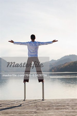 Man Balancing on Dock Ladder, Fuschlsee, Fuschl am See, Salzkammergut, Salzburger Land, Austria