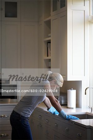 Femme accoudée à l'évier de cuisine