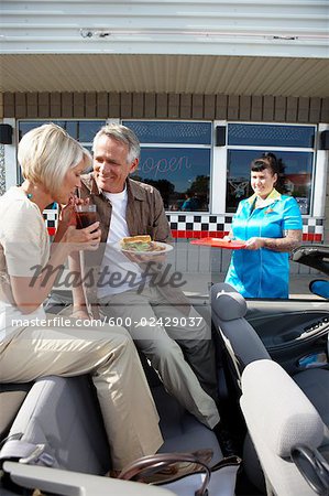 Waitress Serving Couple in Their Convertible at a Retro Diner, Niagara Falls, Ontario, Canada