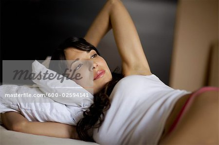 Hispanische Frau liegend auf dem Bett