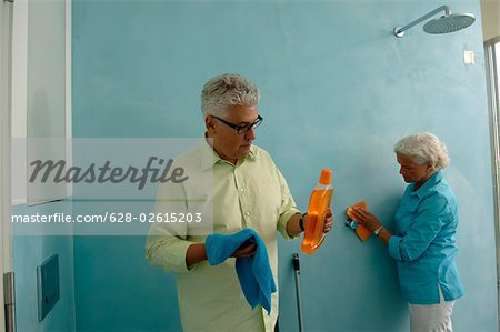 Senior couple cleaning bathroom
