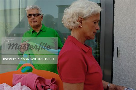 Senior couple hanging out the laundry