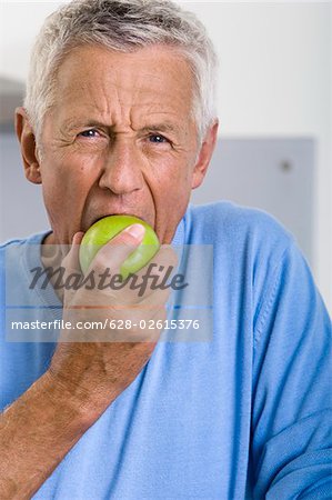 Senior homme mange une pomme