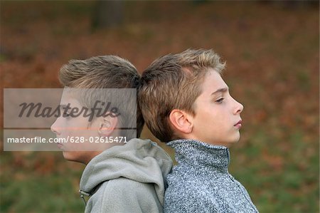 Boy twins standing quietly back to back