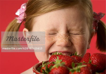 Fille (4-5 ans) avec un bol de fraises