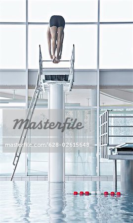 Man jumping from a highboard in an indoor swimming pool