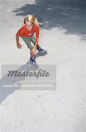 Garçon avec patins à roues alignées des sauts de la Air - Leisure Time Sports - promenade - jeunesse