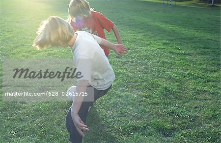 Two Boys playing Soccer - Friends - Leisure Time Sports - Sunset - Meadow