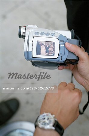 Homme avec un appareil photo numérique qui affiche l'image d'un mariage - technologie