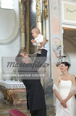Bridegroom holding his Child into the Air - Baptism - Wedding - Church - Tradition - Christianity