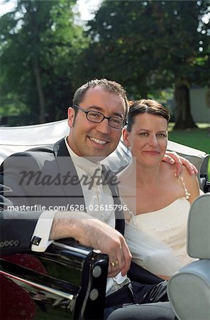 Mariée et marié sur l'arrière d'un mariage de voiture - Automobile - Vintage - harmonie