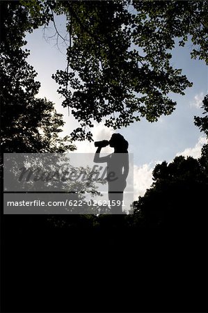 Silhouette of a Jogger relaxing and drinking water