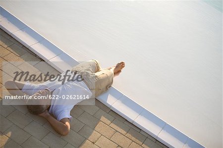 Man relaxing at the edge of pool