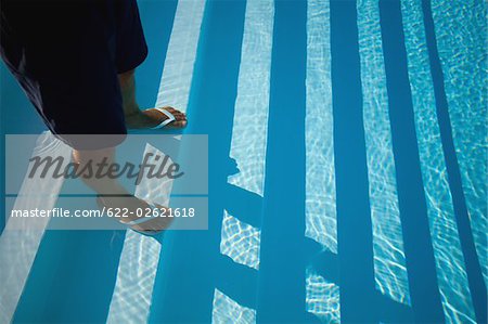 Mann, stehend auf der Treppe des Schwimmbades