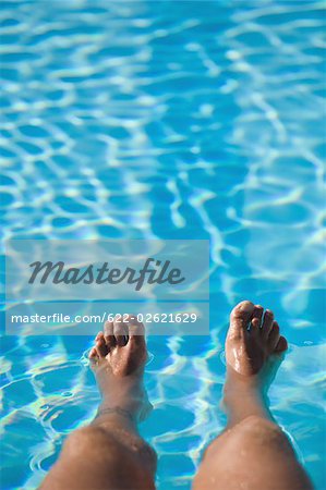 Man with feet in swimming pool