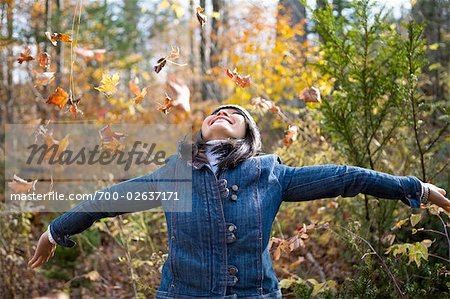 Woman Throwing Autumn Leaves