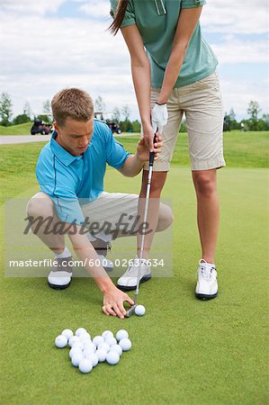 Man Teaching Woman to Golf, Burlington, Ontario, Canada