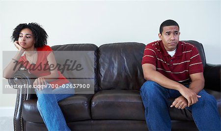 Couple Ignoring Each Other on Sofa