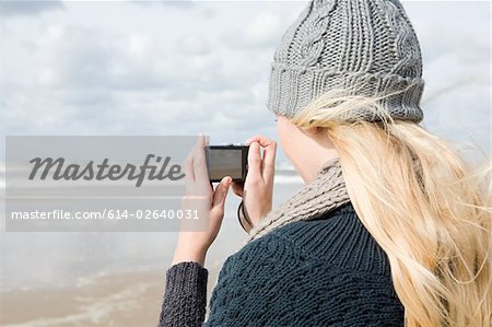 Frau am Meer mit Kamera