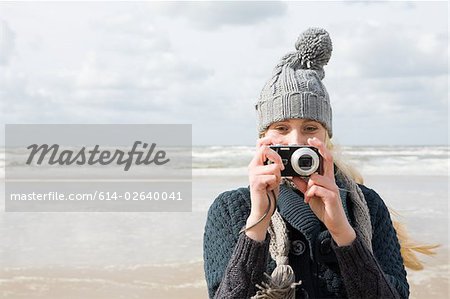 Woman by the sea with camera