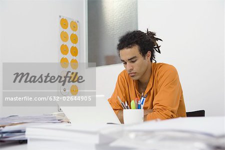 Man working at desk, arms folded