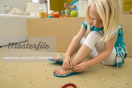 Little girl putting on sandal