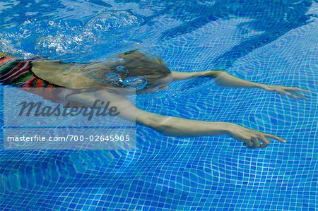 Femme nager sous l'eau dans la piscine