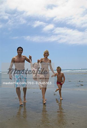 Famille marchant le long de la plage