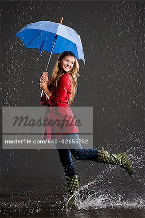 Junge Frau hält einen Regenschirm.