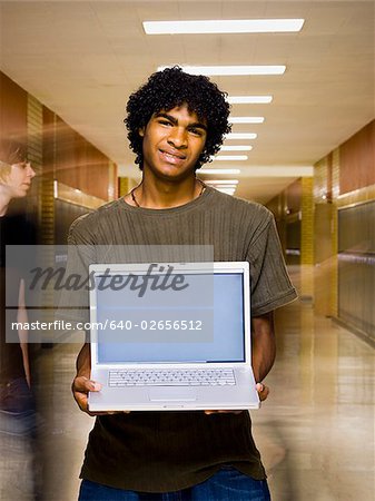 Garçon de l'école secondaire à l'école avec un ordinateur portable.