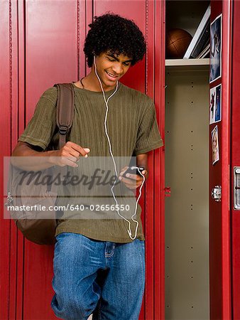 High School boy at school listening to MP3 player.