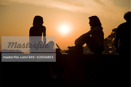 Two people talking at sunset.