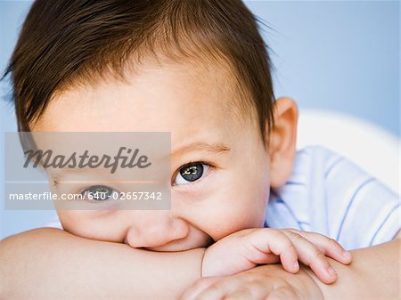 baby boy with arm in mouth.