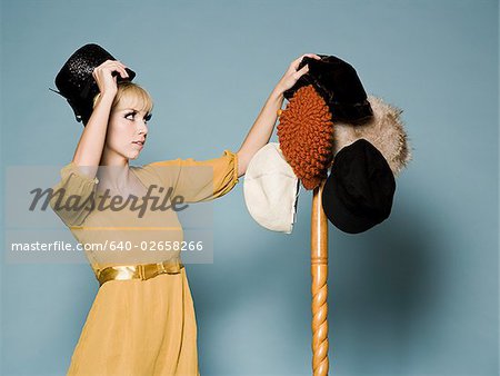 femme en costume des années 1960, essayer des chapeaux