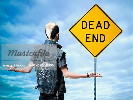 man looking at a dead end sign