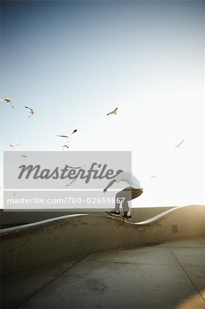 Planche à roulettes sur le rebord de béton de l'homme