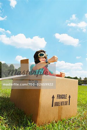 Boy Playing in Cardboard Box