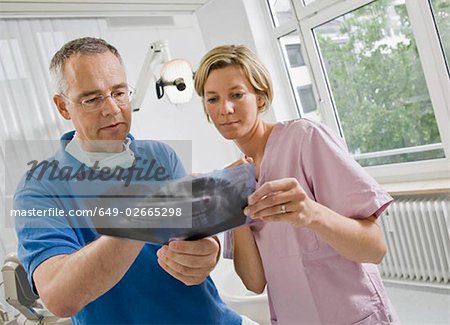 Dentist and assistant looking at x-rays