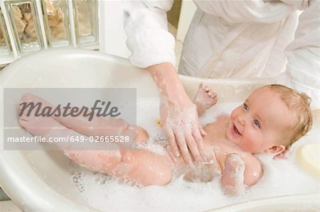 A mother bathing her baby boy